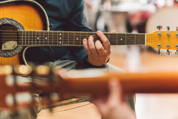 Hands of a man playing the guitar in duet