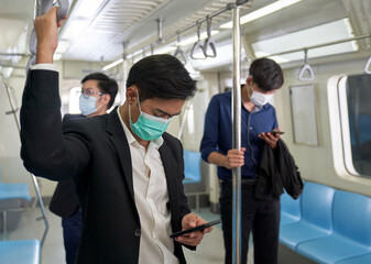 Businessmen wearing face mask protection from covid-19 when they are in underground train for back home