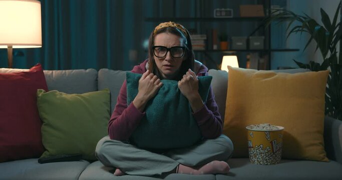 Woman watching a horror movie at home