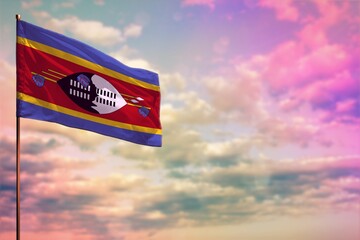 Fluttering Swaziland flag mockup with the space for your content on colorful cloudy sky background.