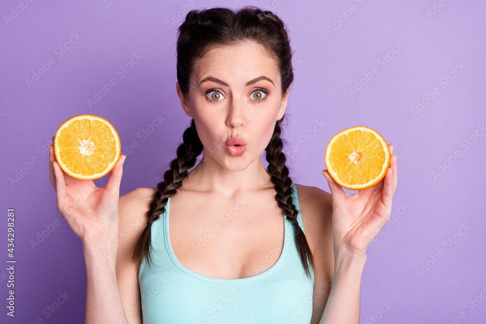 Sticker portrait of attractive cheerful amazed girl holding in hands slices orange isolated over violet purp