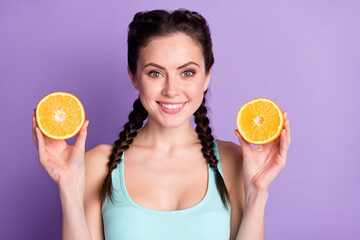 Portrait of attractive cheerful girl holding in hands orange juicy pieces isolated over violet purple color background
