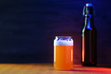 Stylish creative glass of unfiltered wheat beer, beer bottle with a hook cap. Black copy space...