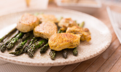 cooked dish. Chicken nuggets with green asparagus on plate