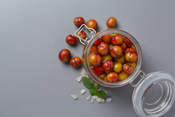 Pickled Plums on gray background.