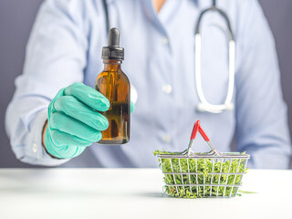 Doctor or Scientist hand holding of cannabis extraction oil bottle and marijuana leaves in a mini basket. Marijuana for medical and business concept.