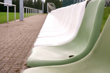 Nahaufnahme von leeren Zuschauersitzen an einem Sportplatz oder im Stadion, selektiver Fokus