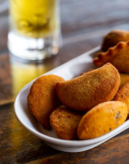A mix of fried snacks with a beer in the background. 