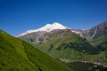 Mount Elbrus is a dormant volcano located in the south-east Caucasus mountain range in Kabardino-Balkaria, Russia. Viem from Cheget mount. July. Panoramic view from Cheget mount slope