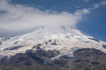Mount Elbrus. Landscape view in the south-east of mount from Cheget mount. Kabardino-Balkaria region, Russia. Its west top and east top top are covered with clouds. They appeared in the afternoon.