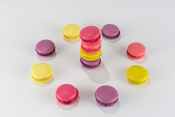 colorful macaroni cakes stacked in a tower and a circle on a white background