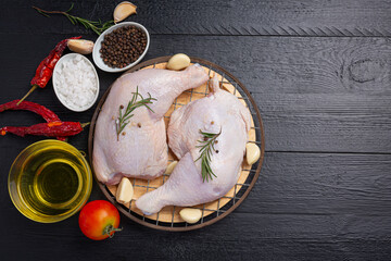 Raw chicken thighs on the dark wooden background.