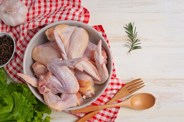 Raw chicken wings on the white wooden background.