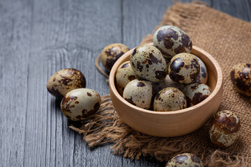 fresh quail eggs on the dark wooden background.