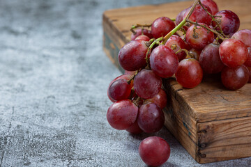 Bunches of fresh ripe red grapes on the dark background.
