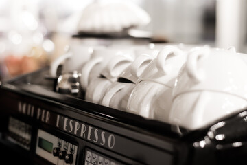 Coffee mugs stacked on top of coffee machine