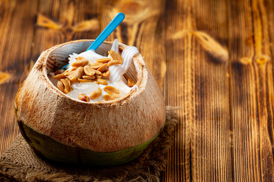 Coconut Milk Ice Cream in the coconut shell on the dark wooden background