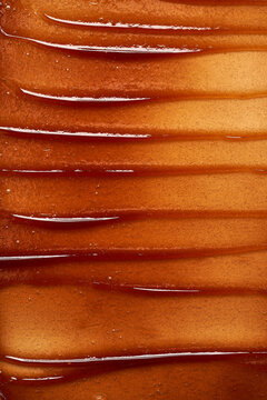 Chocolate colored gel smear and texture. Cosmetic gel or caramel syrup on white background