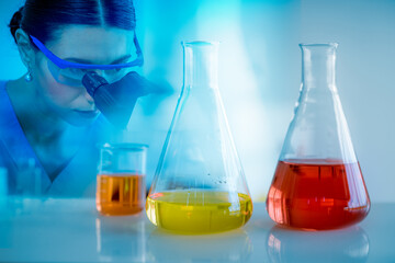 Scientist wearing uniform and glass look at camera test tube in laboratory research and development concept for industry or hospital.