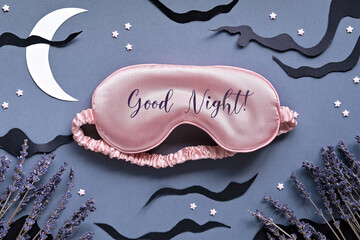 Sleep mask with lavender on dark grey background with black clouds, Moon and stars. Text Good night...