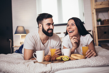 Obraz na płótnie Canvas Cute couple having breakfast and drink coffee in the bedroom.