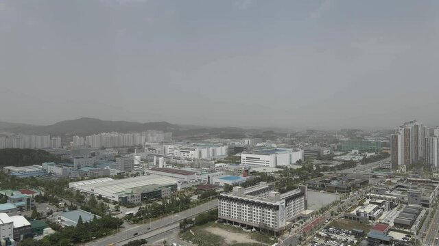 Aerial drone shot flying over Cheonan city covered in smog pollution, South Korea