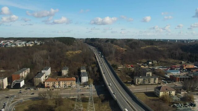 Aerial drone panorama view of highway leading to city from forest.