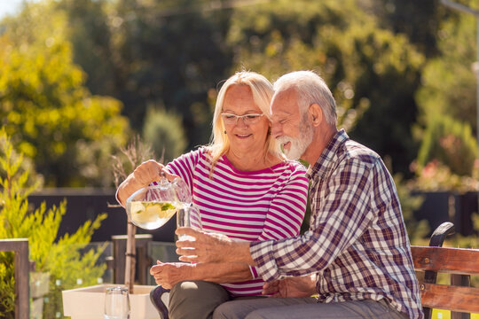 Woman pouring a glass of lemonade for her husband - Powered by Adobe