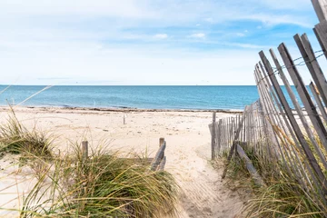 Foto auf Leinwand Path lined with a weathered fence through sand dunes to a beautiful deserted sandy beach on a partly cloudy autumn day. Cape Cod, MA, USA. © alpegor