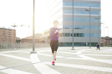 Fototapeta na wymiar young woman running in urban environment