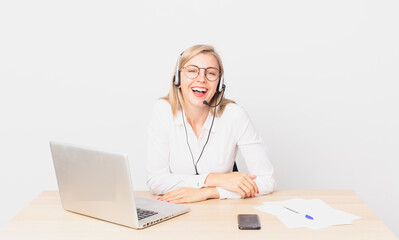 blonde pretty woman young blonde woman laughing out loud at some hilarious joke and working with a...