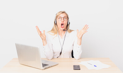 blonde pretty woman young blonde woman amazed, shocked and astonished with an unbelievable surprise...