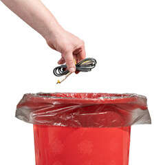 A man tosses a bundle of obsolete wires into a trash can. Male hand throws unnecessary wires into trash bin isolated on white background close up.