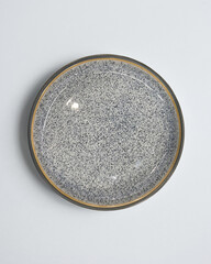 Elegant cutlery view from above on a isolated white background. Top view. Porcelain gray saucer. Trendy plate pastel shades. Flat lay view. Granite texture.