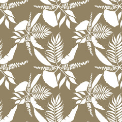 On a brown background there is a composition of tropical leaves.The leaves are white.