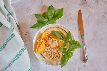 Chickpea hummus flavored with olive oil and sweet paprika and corn nachos.