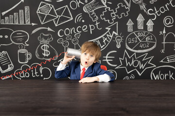 Bright idea! Happy child student against blackboard