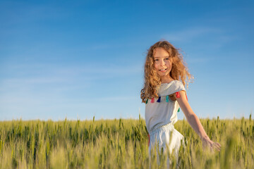 Portrait of beautiful girl against summer field and sky background