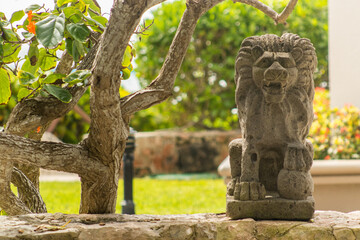 Fototapeta na wymiar Lion statue over stone wall