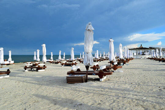 empty beach chairs and umbrellas after opening time (in the evening) - Navodari, Constanta, Dobrudja, Romania, Europe, Black Sea