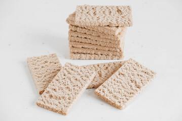 Stacked rye crisp bread on a white wooden background. Copy, empty space for text