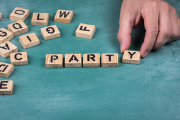 Party. Wooden alphabet letters on a green blackboard background