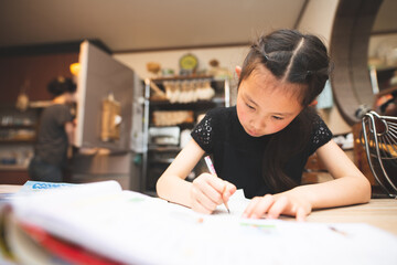 自宅のキッチンで勉強をする女の子