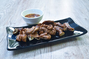 grilled slice pork intestine on plate dipping spicy sauce