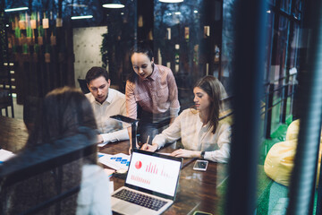 Serious colleagues discussing statistics in workplace