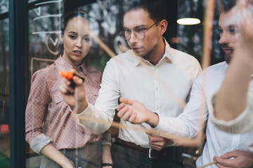 Focused colleagues discussing business issues and taking notes