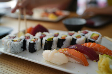 Sushi set on the stone plate. Rainbow roll and 3 kinds of different sushi