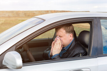 Man allergic to grass pollen runny nose in car.