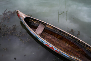Top view of small wooden canoe on the river bank.
