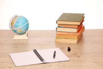 There is a globe and study materials on the table in the library to prepare for exams.